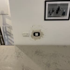 שקע חשמל בקיר עם סימני תיקון סביבו