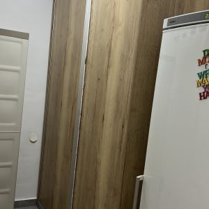 ארון עץ עם דלתות הזזה ומקרר לבן