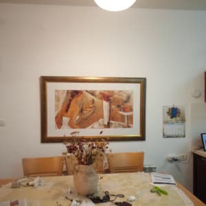 ציור עם דמויות מופשטות במסגרת זהב על הקיר