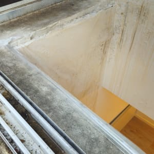 חלון עם מסגרת מתכת וקיר מתקלף