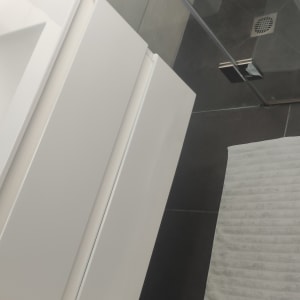 מקלחת עם אריחים, ראש מקלחת ובקבוק ניקוי