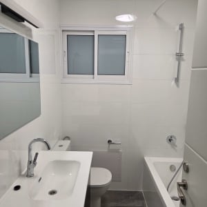 חדר אמבטיה משופץ עם כיור, אמבטיה וחלון