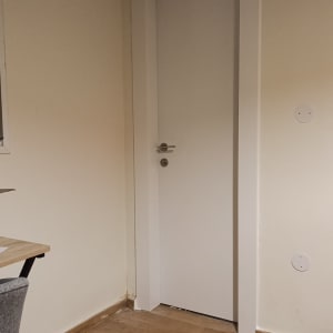 דלת לבנה בחדר עם רצפת עץ