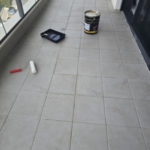 רולר, מגש צבע ודלי על רצפת מרפסת