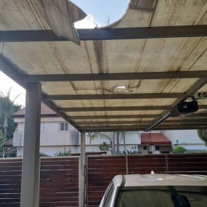 גג אלומיניום פגום עם חור מעל רכב חונה