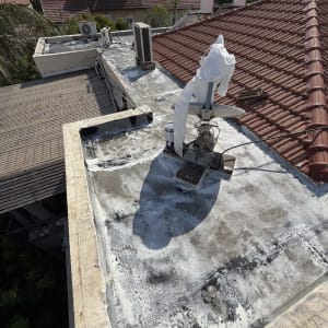 עבודת הלבנה ואיטום של גג שטוח על ידי בעל מקצוע בחליפת מיגון