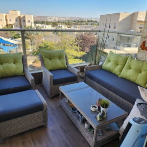 כריות ירוקות על ריהוט גן מרופד במרפסת