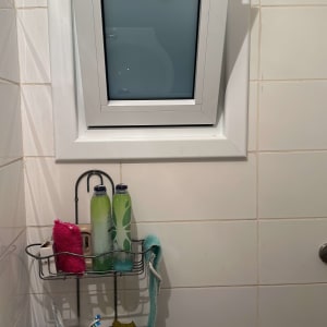 חלון קטן עם תריסים סגורים בחדר אמבטיה