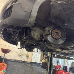 רכב מורם במוסך עם גלגל קדמי מפורק