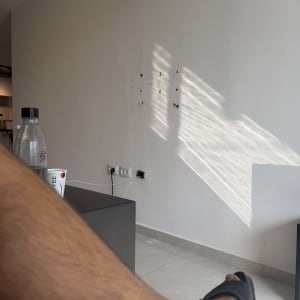 קיר לבן עם חורים וסימני קידוח ושקעי חשמל בדירה