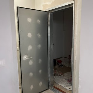 דלת מתכת פתוחה עם ידית לבנה