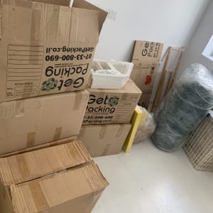 קופסאות קרטון וציוד ארוז בחדר, קשור להובלות