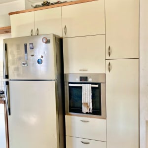 מקרר ותנור במטבח מודרני עם ארונות לבנים