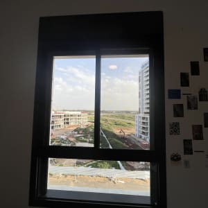 נוף עירוני מבעד לחלון עם בניינים ועבודות בנייה