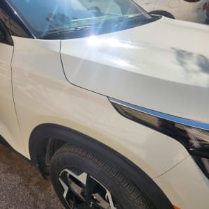 מכונית לבנה עם שמשה קדמית וגלגל קדמי