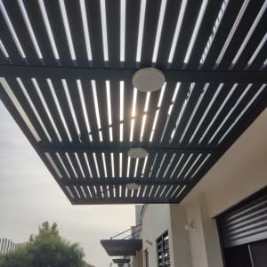 תאורה מותקנת על פרגולה מתכתית בחוץ