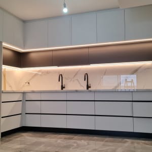 מטבח מודרני עם ארונות לבנים וברזים שחורים