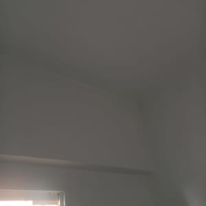 קיר ותקרה צבועים בלבן עם חלון פתוח