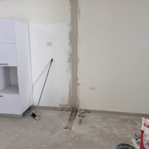 קיר עם תיקון טיח, כלים וחומרים לריצוף