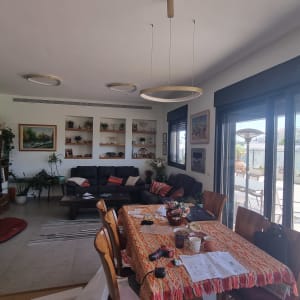 סלון ביתי עם שולחן אוכל ומרפסת חיצונית