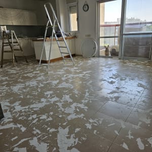 סולם וחלקי צבע על הרצפה בחדר