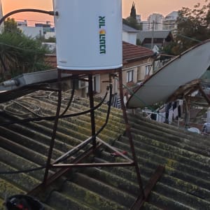 דוד שמש מותקן על גג עם כלים לידו