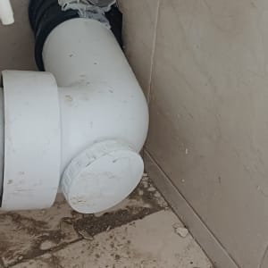 צנרת לבנה עם חיבורים על רצפה מלוכלכת