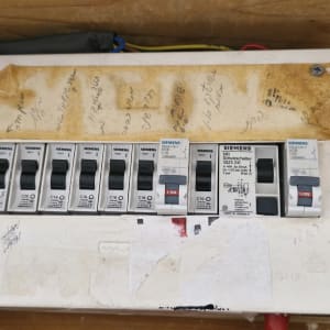 לוח חשמל עם מפסקים של סימנס על רקע עץ