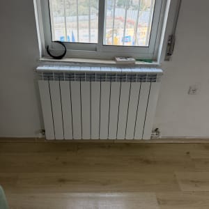 רדיאטור מתחת לחלון עם נוף עירוני