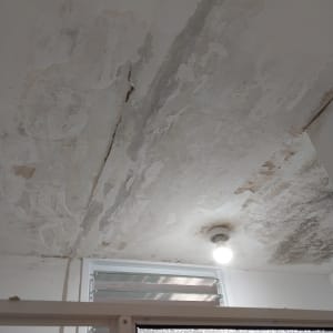 תקרה מתקלפת עם סימני רטיבות וכתמים כהים