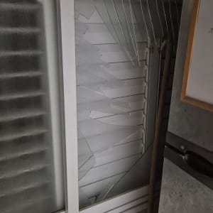 זכוכית שבורה במסגרת חלון לבן