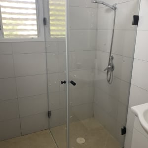 מקלחון זכוכית עם ראש מקלחת בחדר אמבטיה