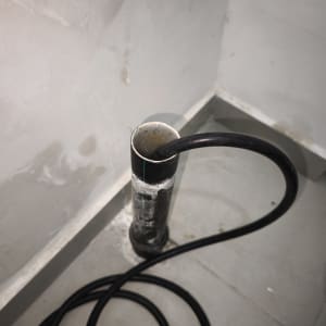 צינור שחור מחובר לקיר עם חיבורי מים