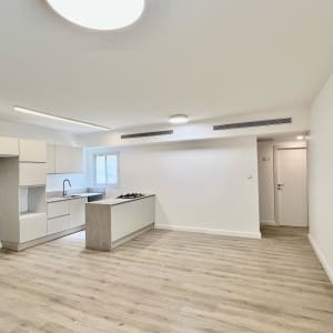 מטבח מודרני עם ארונות לבנים ומשטח עבודה אפור