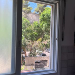 חלון אלומיניום פתוח עם מסגרת לבנה