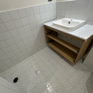 כיור לבן על ארון עץ בחדר רחצה נקי