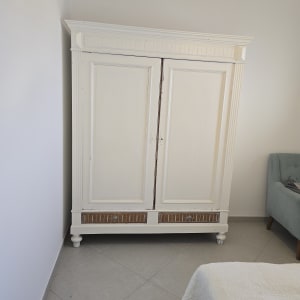 ארון עץ לבן עם דלתות סגורות בחדר שינה