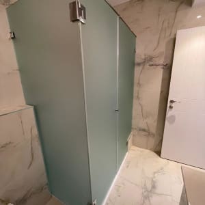 מקלחון זכוכית בחדר אמבטיה מודרני עם קירות שיש.