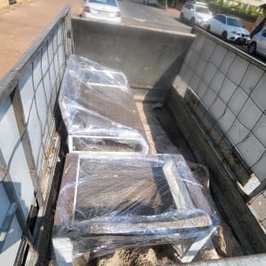 רהיטים עטופים בניילון על משאית הובלה ברחוב עירוני