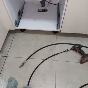 כלי עבודה וצינור מתחת לכיור במטבח