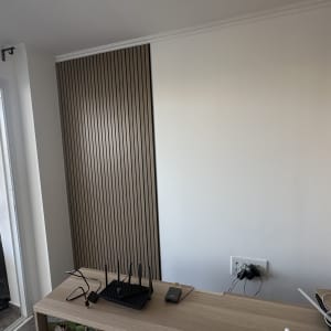 קיר עם חיפוי עץ ושולחן עם נתב אינטרנט