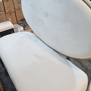 ספה לבנה עם כתמים, קרטונים ברקע