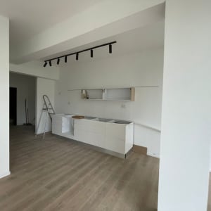 קיר גבס לבן עם מדפים ומטבח בהתקנה