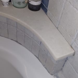 מוצרים על מדף באמבטיה עם אריחים כחולים