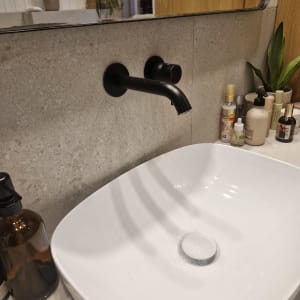 כיור וברז בחדר אמבטיה עם מוצרי טיפוח