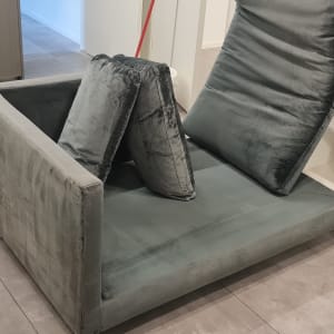 ספה עם כריות ומכונת ניקוי בצד