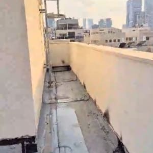 גג עם איטום ביטומני וסימני תיקון לאורך הקירות