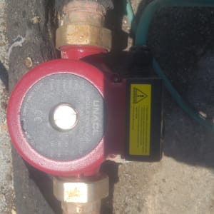 משאבה אדומה עם צינורות על רקע בטון