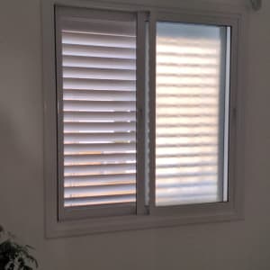 חלון עם תריסים סגורים ומזגן מעליו