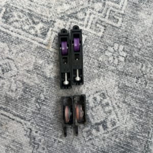 גלגלים לתריסים על רקע שטיח אפור